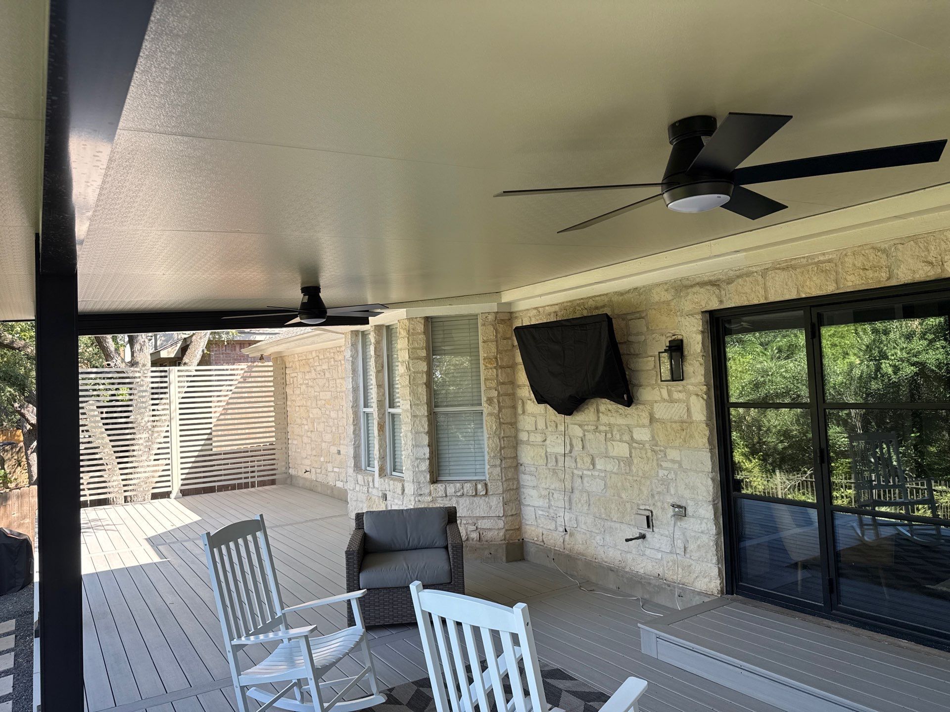 Patio cover interior with ceiling fan and outdoor TV mount - Austin TX