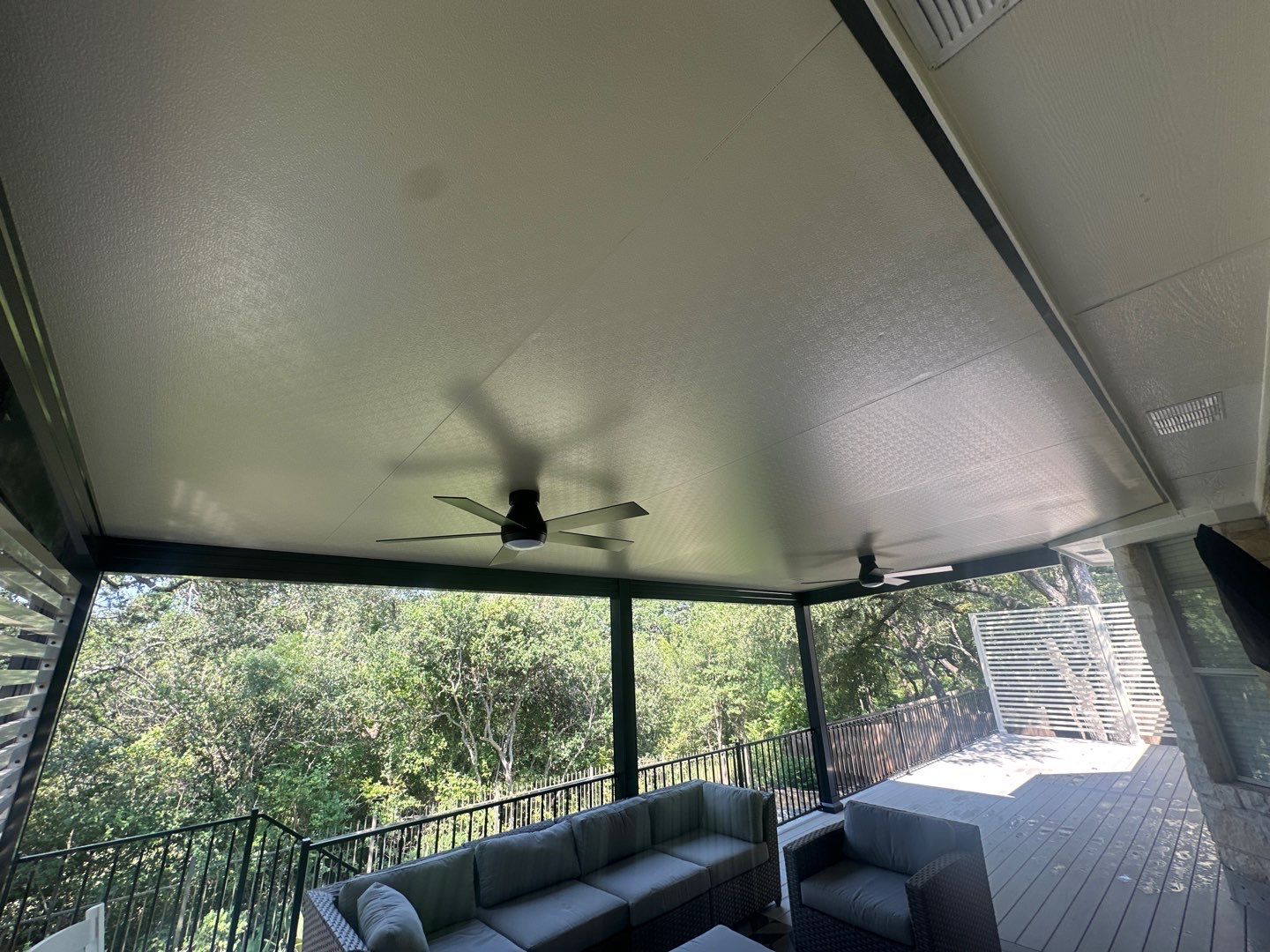 Covered patio outdoor living area with stone home - Austin TX