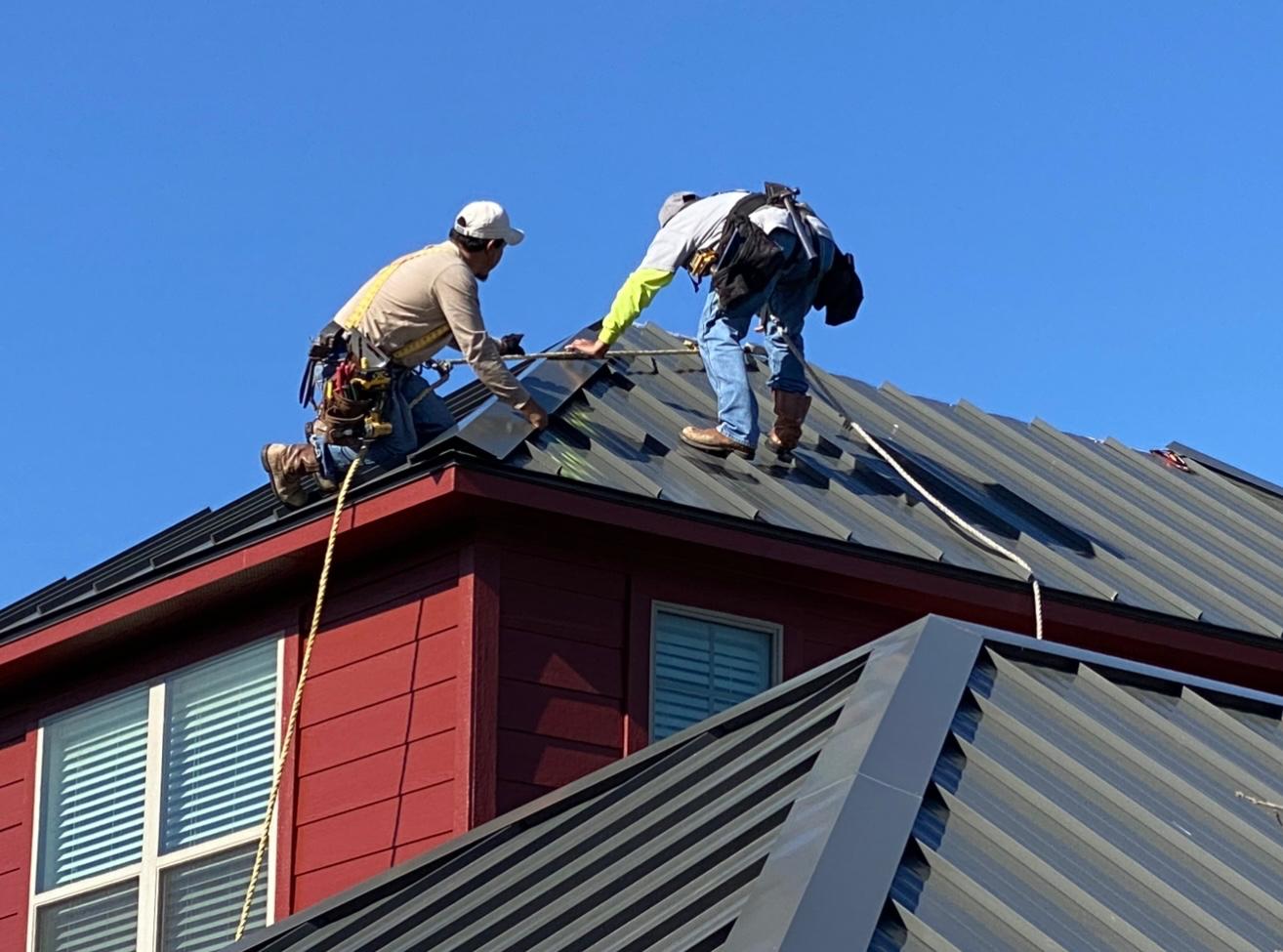 Metal roof installation crew on residential home - Austin TX